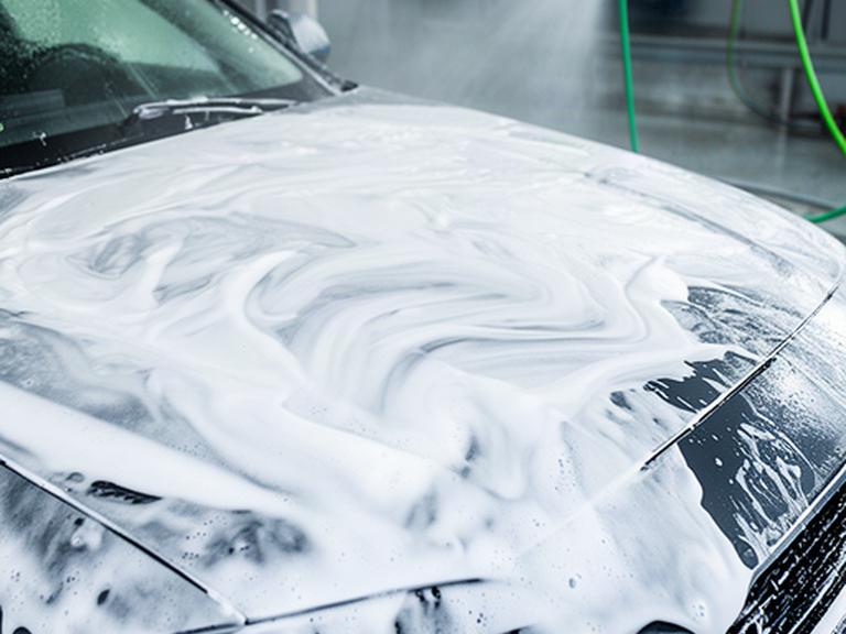 Schiuma di shampoo neutro sulla carrozzeria di un’automobile